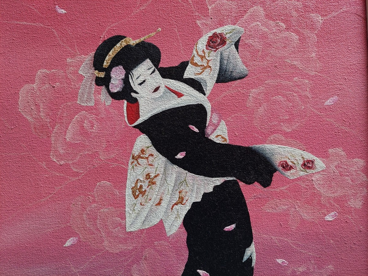 Dancing Japanese girl in a bright outfit among the petals of pink