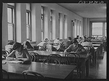 Bob Aden (at the second table) studying in the library. University of Nebraska,