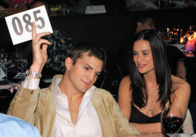 Actor Ashton Kutcher bids on an item as his wife actress Demi Moor - Old Photo
