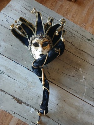 Venetian jester mask, also known as a Joker mask, featuring a handle.