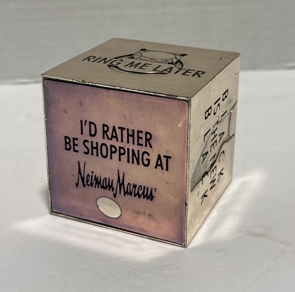 A chrome cube paperweight from Neiman Marcus — minimalist, weighty, and the kind of 'where did you get that?' object that lives on a desk forever.