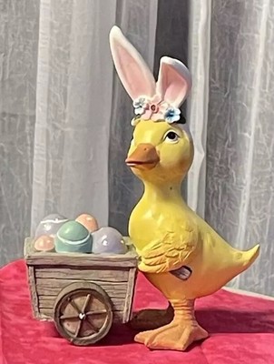 Easter Yellow Duck Pushing a Cart full of colorful painted eggs