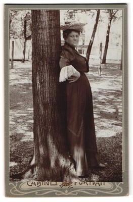 Fotografie Dame mit Hut, an einen Baum gelehnt 