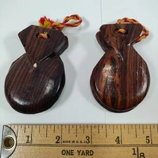 Vintage hand-carved wooden castanets with braided cord. 