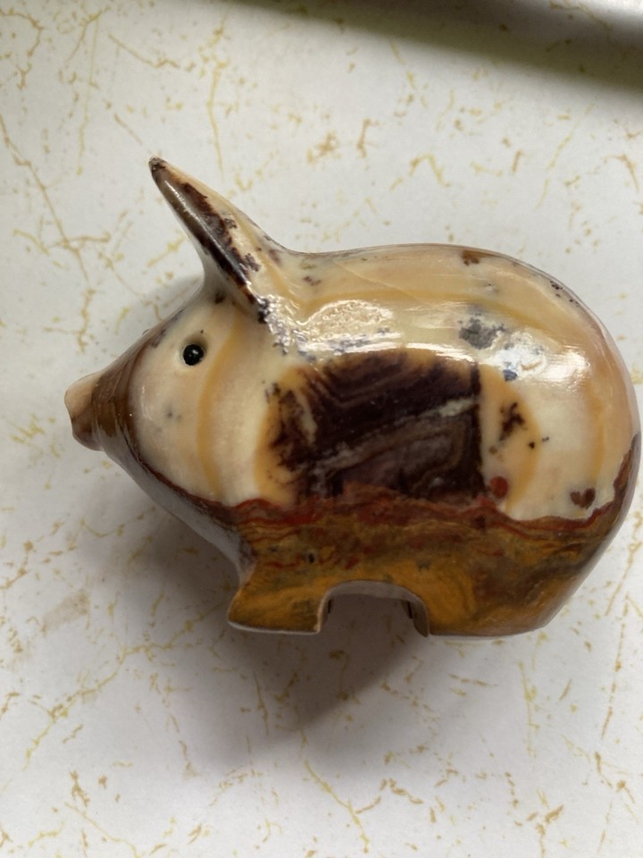 A hand-carved stone pig pencil holder with a genuine tiger eye mineral pattern — bizarre, beautiful, and utterly one-of-a-kind.