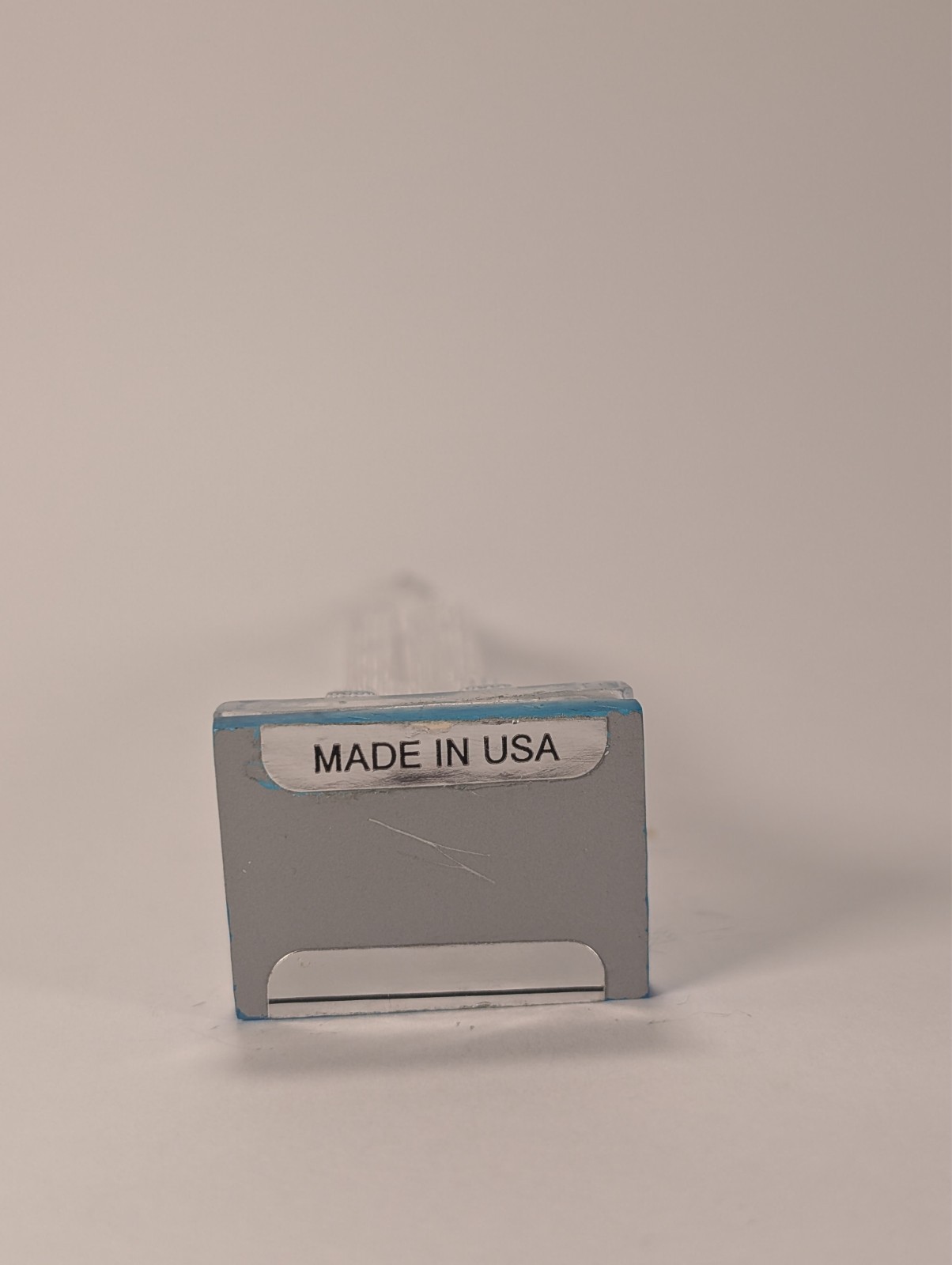 Silver vintage Lucite Empire State Building miniature souvenir with blue text reading “MADE IN U.S.A.” on white background.