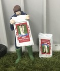 ,HLT, Granjero vaciando una bolsa de leche en polvo para corderos, 1/32, WM078F