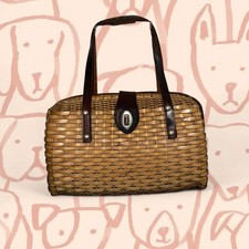 vintage wicker handbag with brown leather straps and a turn-clasp closure.
