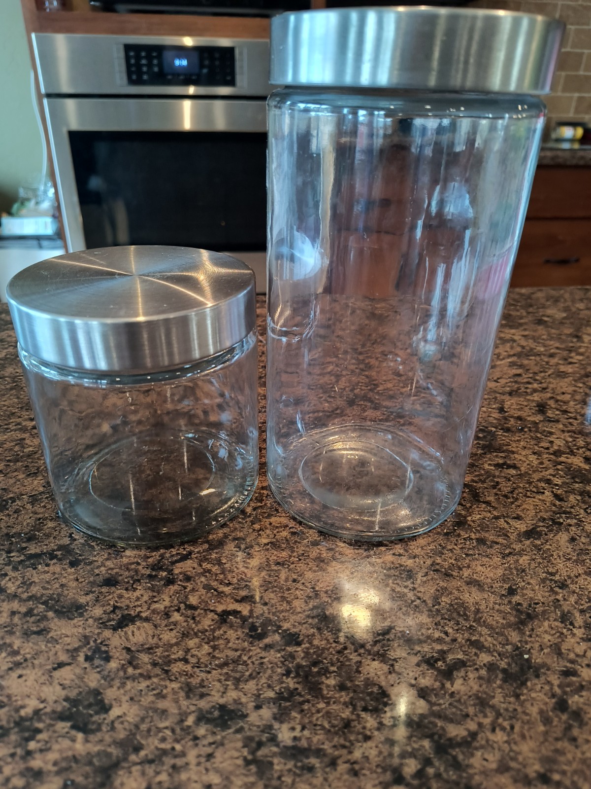 glass storage jars with stainless steel lids are  part of a kitchen canister set