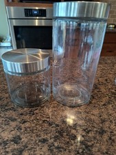 glass storage jars with stainless steel lids are part of a kitchen canister set