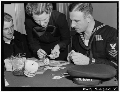 Washington, D.C. A sailor getting some help in wrapping his Christmas gifts at