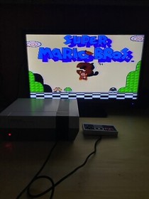 NES with Mario/Duck Hunt/track & field, Super Mario 2, and Super Mario 3 carts