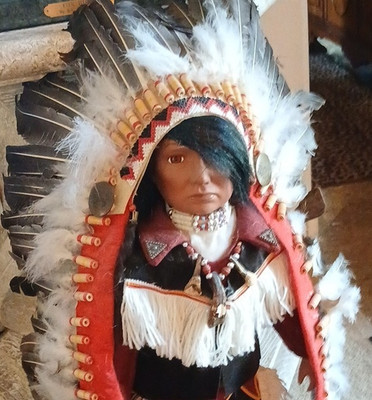 Puppe im indianischen Stil mit Federkopfschmuck und Trachtenkleidung