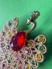 ELEGANTE VINTAGE PFAUEN-BROSCHE IN GOLDOPTIK MIT ROTEM STEIN
