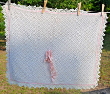 Homemade white crocheted baby blanket pastel pink backing