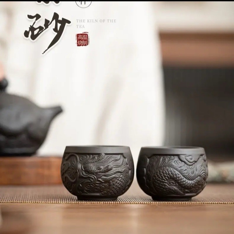 A pair of purple clay teacups with black dragon patterns
