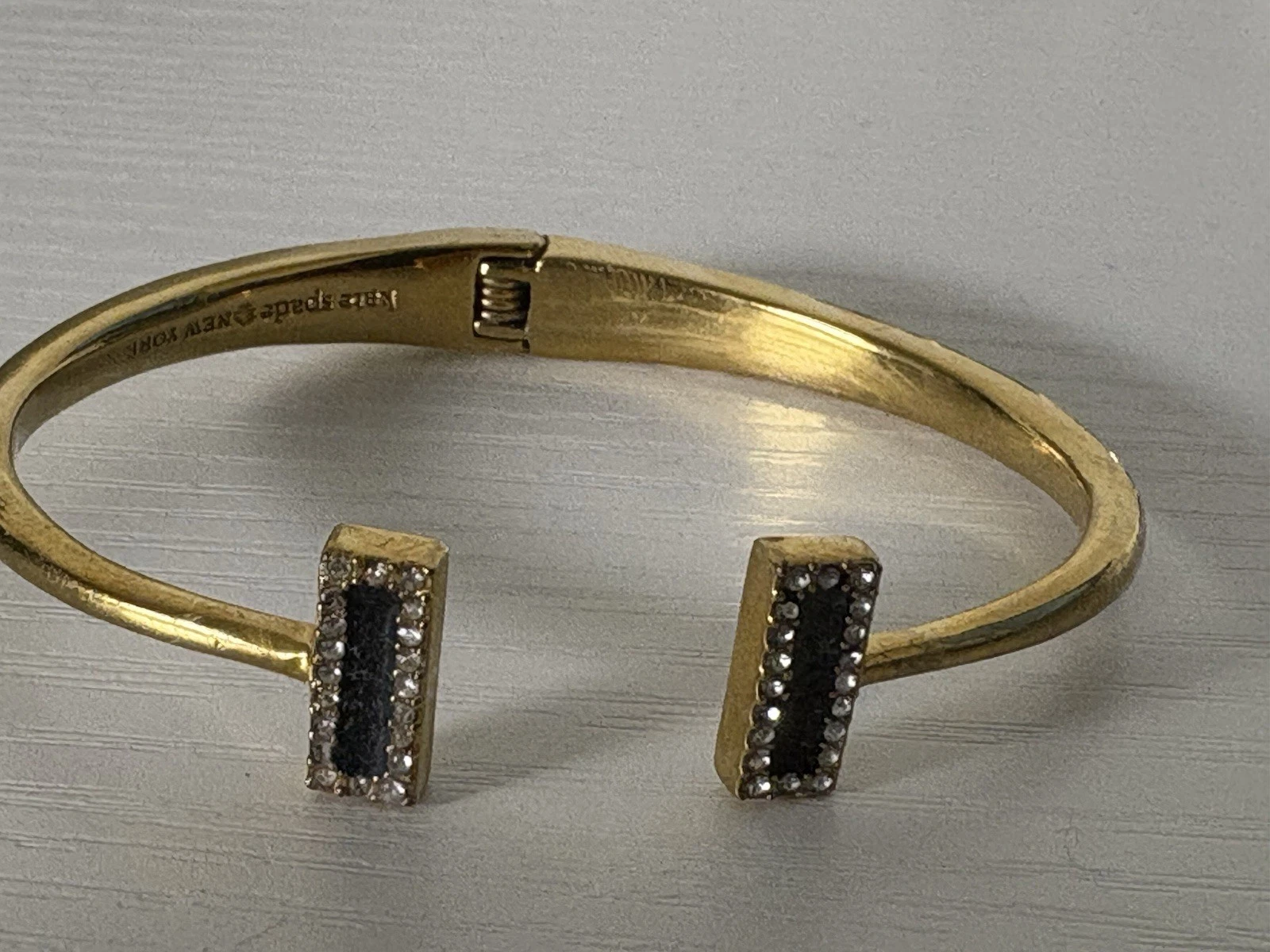 BRACCIALE APERTO KATE SPADE NEW YORK ORO MORSETTO A MOLLA SMALTO E ZIRCONI