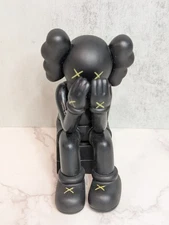 Kaws Figure Companion Passing Through Black Seated Hands Covering Face No Box
