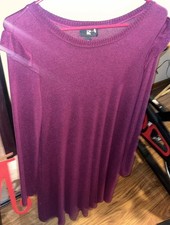 This is a plum purple knit sweater dress with ruffled shoulders.