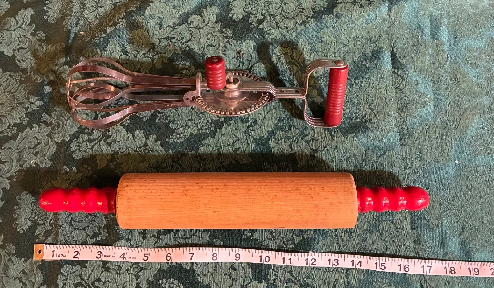 Vintage wooden rolling pin with red and rotary hand beater