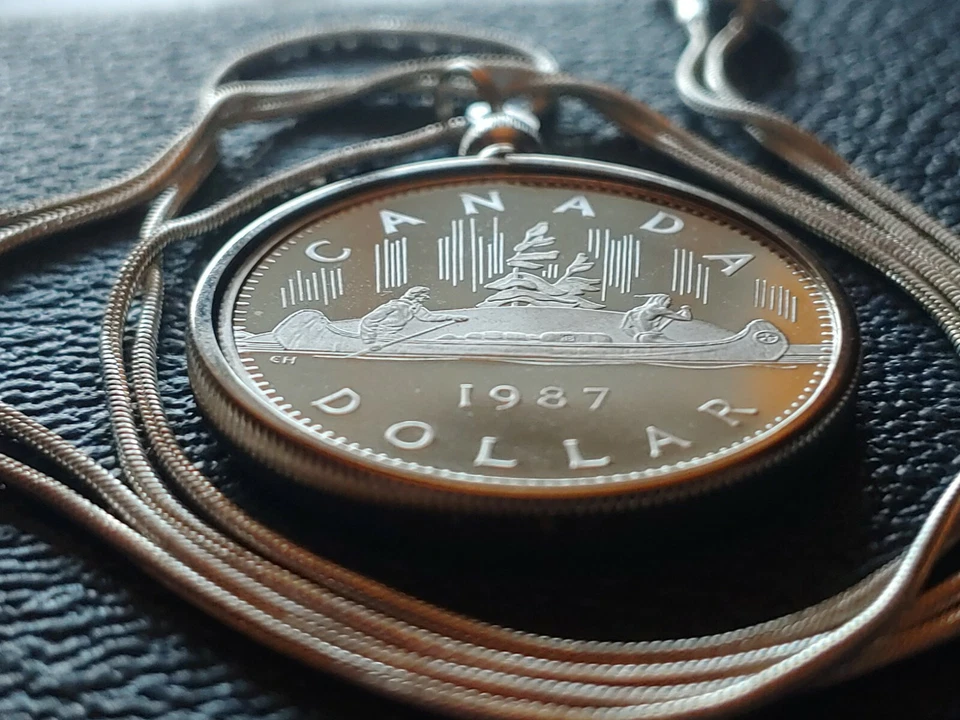Colgante con bisel de moneda de dólar canoa 1987 de Canadá en una cadena llena de oro blanco de 28". Foto 3 de 4
