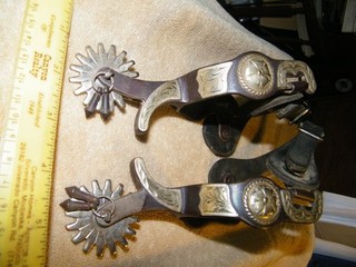 pair of spurs silver color concho mounting leather straps jingle bobs
