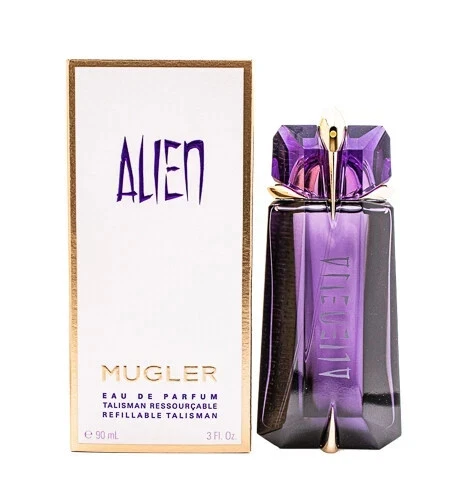 Purple bottle of Thierry Mugler Alien EDP perfume with silver cap beside beige box labeled “Alien” on white background.