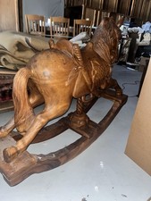 Stunning hand-carved wooden rocking horse with intricate detailing.