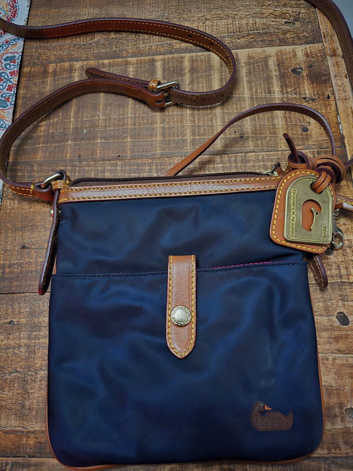 Dooney & Bourke dark blue crossbody bag with brown leather trim