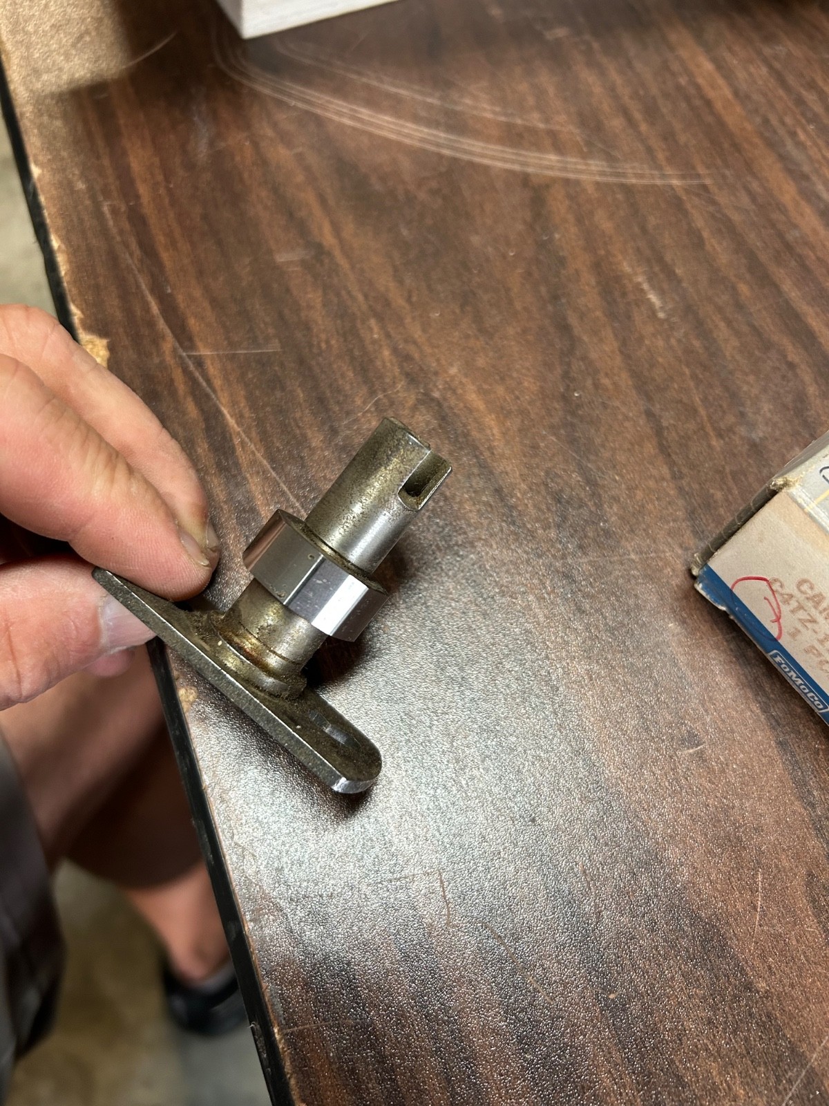 Metallic 1964-1966 Ford truck distributor cam with brass shaft and black side handle, worn by age and use.
