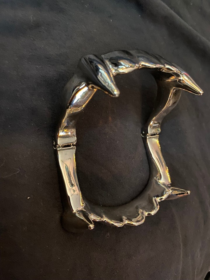 Absurdly oversized metal vampire fangs that exist purely to confuse and delight anyone who walks into a room — peak conversation-starting décor.