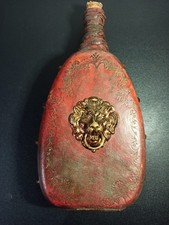 Ancienne gourde en cuir repoussé rouge motif tête de lion