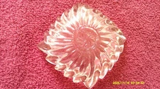 Clear glass ashtray with a swirl and a pinwheel design and sawtooth edge