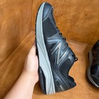 Black and gray New Balance 1540V2 men’s running shoe with mesh upper, suede overlay, and large white “N” logo on sides.