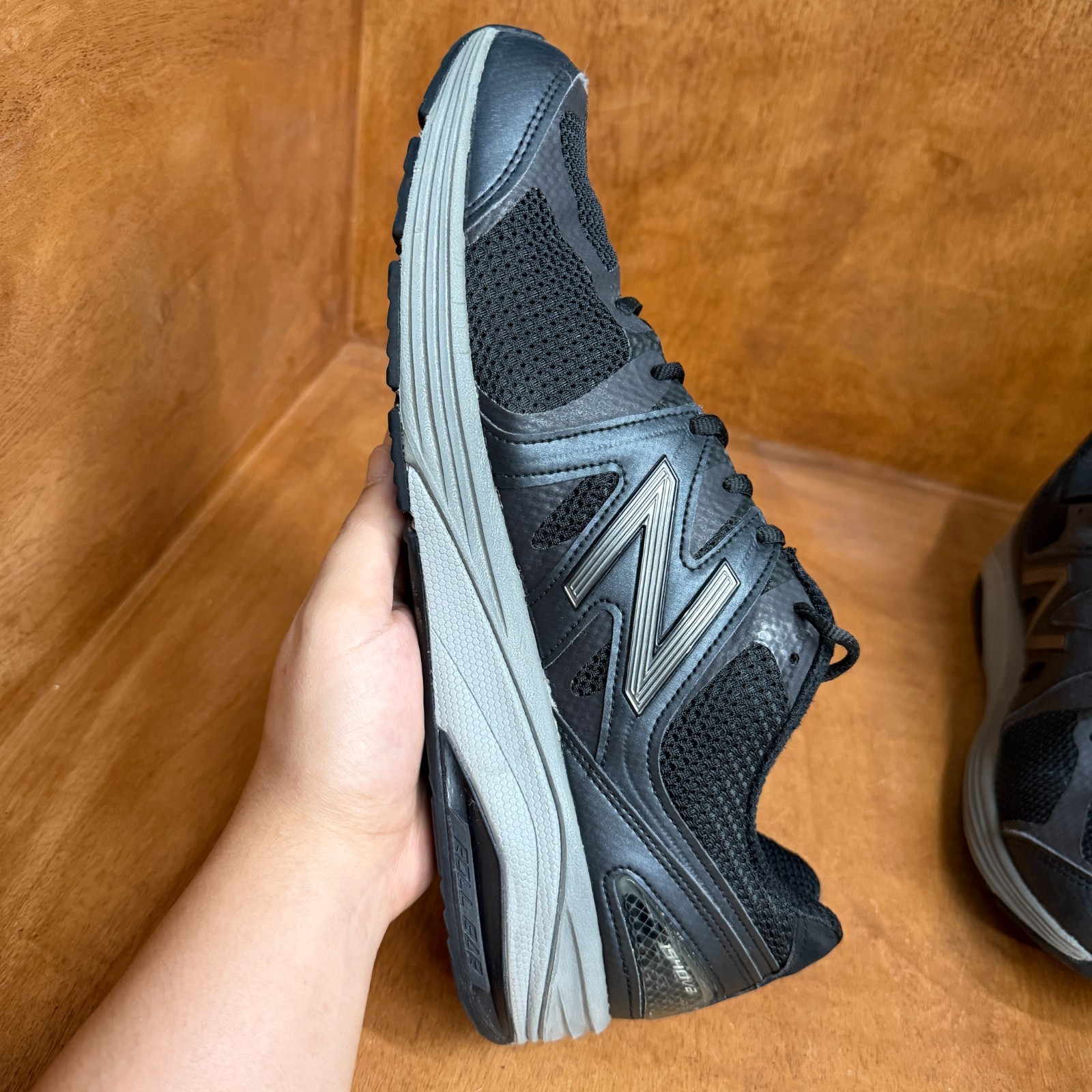 Black and gray New Balance 1540V2 men’s running shoe with mesh upper, suede overlay, and large white “N” logo on sides.