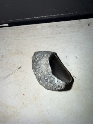 Kleiner Naturstein (Kirschstein) am Strand gefunden. Glatte dunkelgraue Innenausstattung