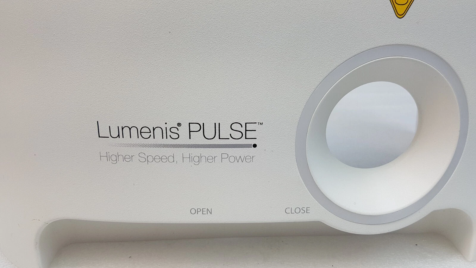 Close-up of the Lumenis PULSE Higher Speed Higher Power logo and OPEN/CLOSE port bezel
