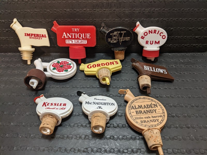 LOT of 10 DIFFERENT VINTAGE PLASTIC ADVERTISING LIQUOR POURERS ....... BARWARE