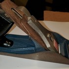Vintage blackhawk C557MP wood hand plane with worn silver blade and dark wood handle, blue metal base, made in USA.