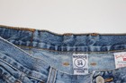 Brown paint splatter VTG Lucky Brand jeans, size 34x30, with yellow “American Made” tag on waistband.