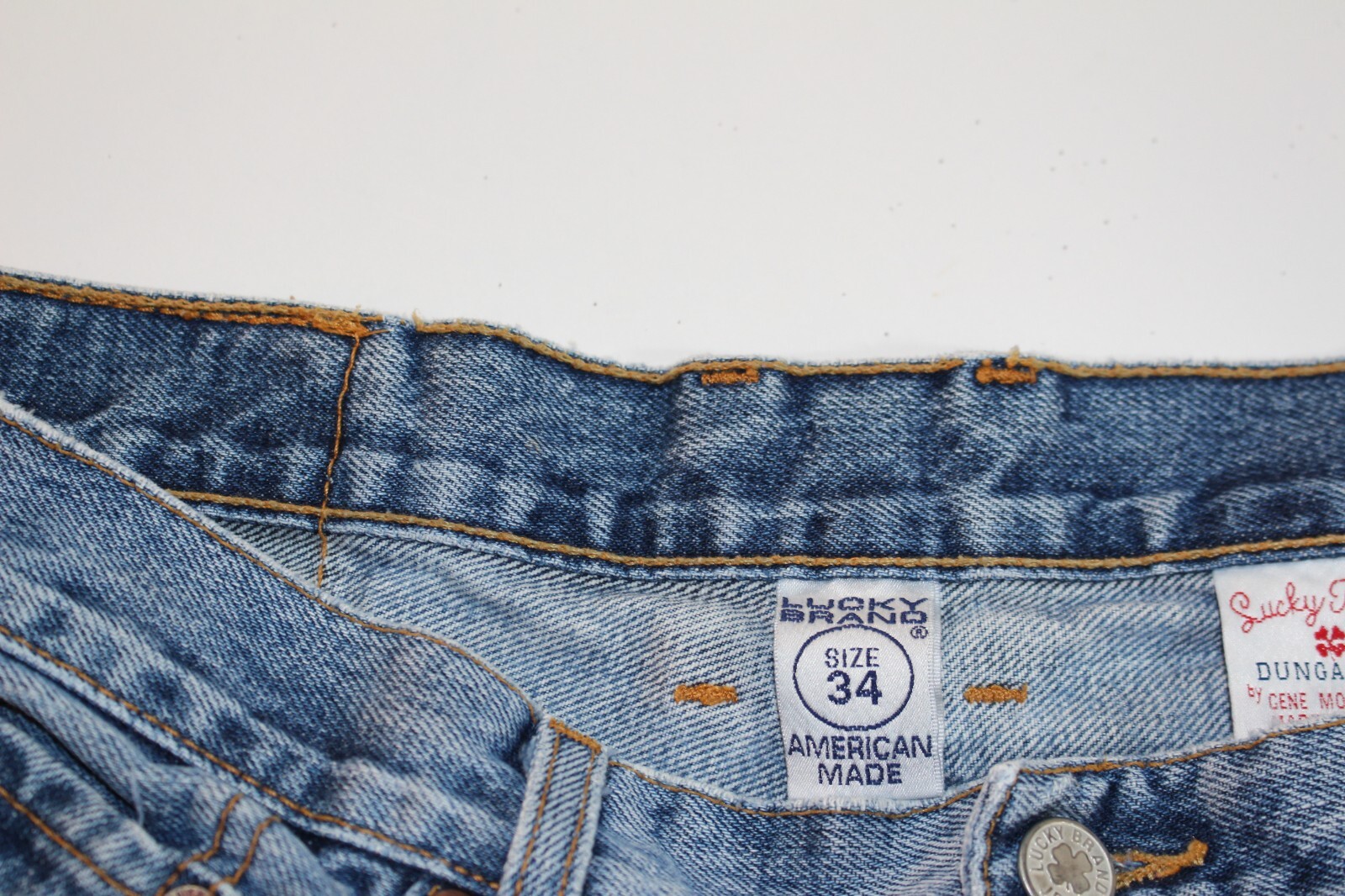 Brown paint splatter VTG Lucky Brand jeans, size 34x30, with yellow “American Made” tag on waistband.