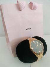 Reloj dorado con esfera negra y detalles coloridos