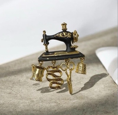 Machine broochblack with gold circlewith hanging accessories