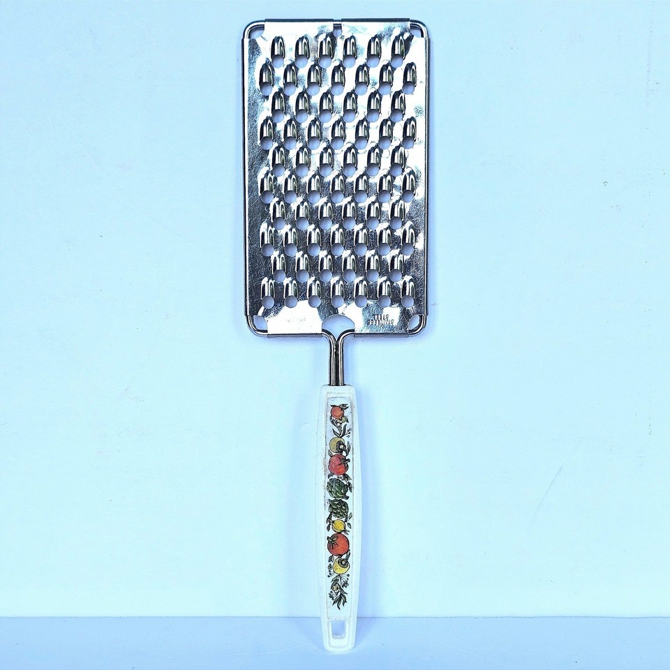A vintage Ekco stainless steel grater with a charming hand-painted fruit decal handle — the kind of retro kitchen object that's as decorative as it is functional.