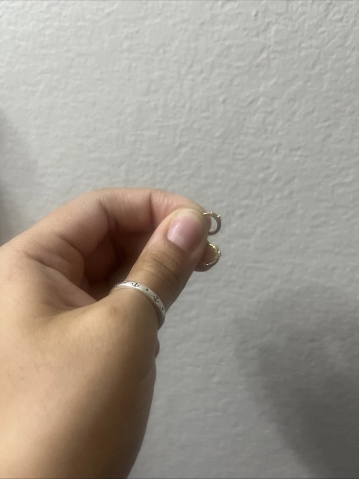 Pendientes Huggie de oro amarillo macizo de 14k con diamante pequeño en el centro Foto 2 de 4