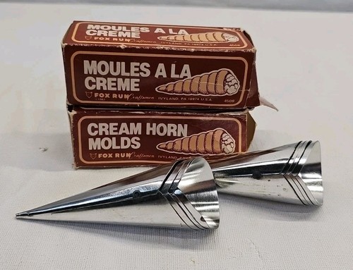 Set of eight silver cone-shaped Fox Run Cream Horn Molds with tapered bodies, shown with branded boxes and product text.