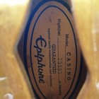 Gold oval Epiphone label with white text, “Number 75597 Casino,” and guarantees against faulty workmanship and materials.