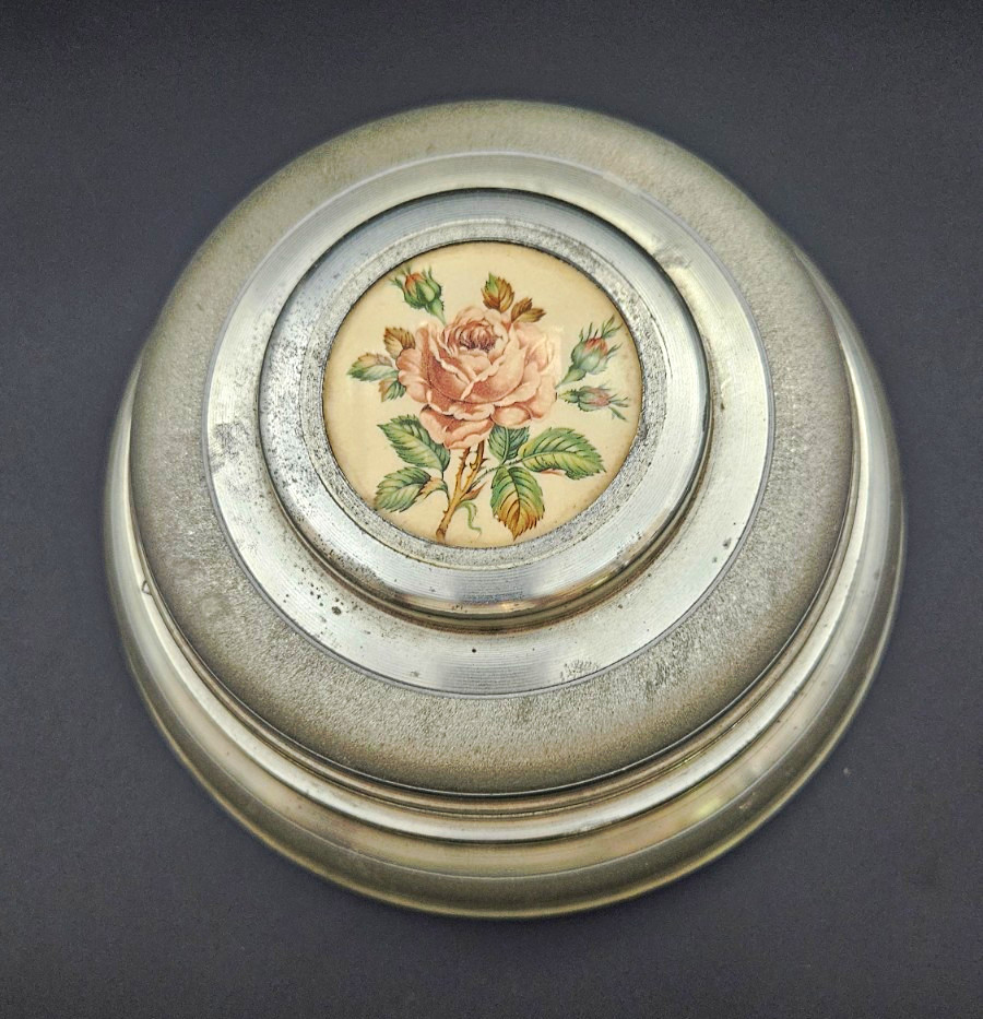 A 8-inch spinning metal musical trinket dish that doubles as functional desk or vanity art — the kind of dual-purpose vintage object that earns a permanent spot on a shelf.