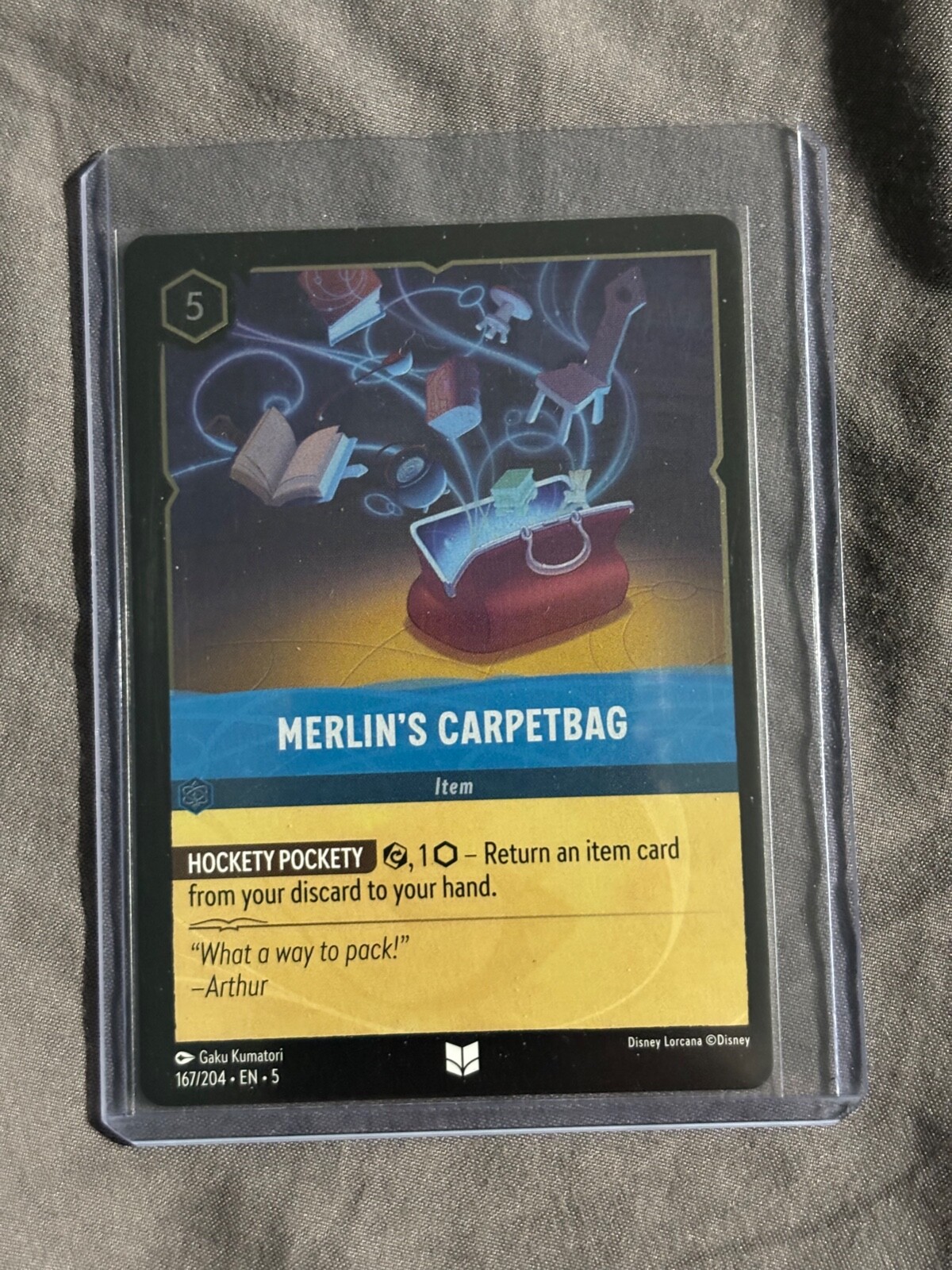Disney Lorcana Shimmering Skies Merlin’s Carpetbag Cold Foil 167/204 NM