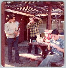 Vtg Color Snapshot Group Men Woman Hunting Rifle Picnic Table Outdoors 1970s
